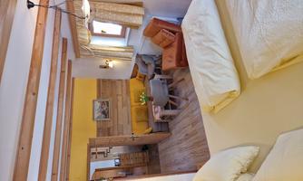 A cozy room with a double bed and a seating area. The bright decor creates an inviting atmosphere.