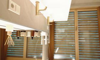A modern bathroom environment with elegant fixtures and a large window. The blinds are half-closed, providing diffuse lighting.