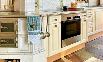 A modern kitchen with a stylish stove and elegant kitchen shelves. Cooking utensils and a pot are on the countertop.