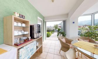A bright and inviting room with a modern buffet and a view of the garden. The room is tastefully furnished and offers cozy seating.