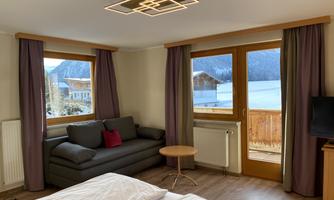 A comfortable room with a sofa and a breathtaking view of the mountains. The large windows let in plenty of light and create a cozy atmosphere.