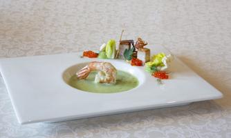 An artistically arranged plate with a shrimp and colorful vegetables. The presentation is elegant and playful.