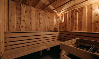A cozy sauna with wooden walls and benches. The room exudes warmth and relaxation.