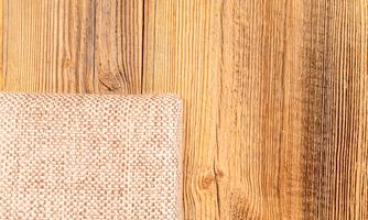 A wooden background with a textured textile surface in the corner. The colors are warm and natural.