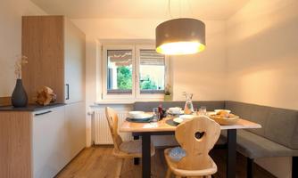 A cozy dining area with a table and chairs. Large windows provide plenty of daylight and create an inviting atmosphere.