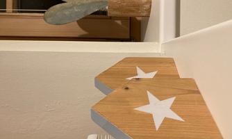 Wooden cottage with white stars and a heart-shaped decorative element on the windowsill. The elements give the room a cozy atmosphere.