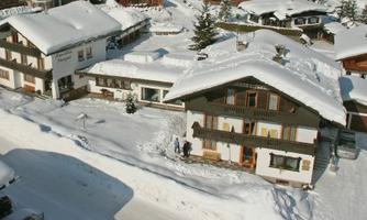 A snow-covered village with several houses. The surroundings are quiet and wintry.