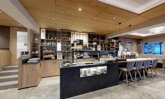 A modern café with wooden shelves, a counter, and elegant chairs. The atmosphere is friendly and inviting.