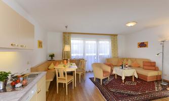 A cozy apartment with a modern kitchenette and an inviting living area. Large windows provide plenty of light and a friendly atmosphere.