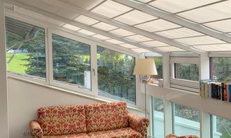 A bright living room with large windows and cozy sofas. The decor is modern and welcoming.