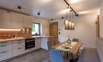 A modern kitchen with a dining area. The room is well-lit and offers a cozy atmosphere.