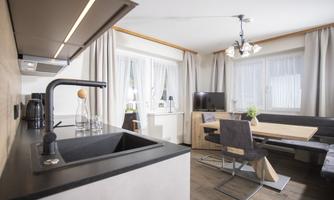 A modern kitchen with an open living area design. The space is brightly lit and comfortably furnished.