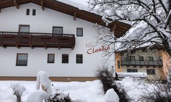 A cozy house in a snow-covered winter landscape. The surroundings are quiet and idyllic with snow-covered trees.