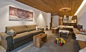 A modern living room with a comfortable sofa and a wooden table. The warm lighting creates an inviting atmosphere.