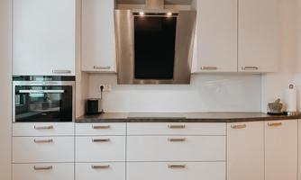 A modern kitchen with white cabinets and an elegant cooktop. The layout is clean and functional, perfect for cooking.