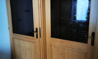 Two stylish wooden doors with glass windows that create an inviting impression. The floor features square tiles in warm tones.