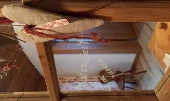 A decorative frame with a heart-shaped pendant and a friendly message. In the background, a cozy room is visible.