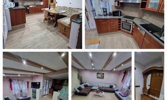 A modern apartment with a fully equipped kitchen and a spacious living room. The interior is bright and inviting, with stylish furniture and wood decor.
