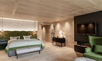 A modern bedroom with wooden paneling and elegant furnishings. The room features a comfortable bed, a television, and a relaxing seating area.