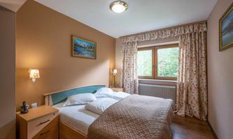 A cozy bedroom with a double bed and a window that lets in plenty of light. The walls are painted in warm colors and there is nice decoration.