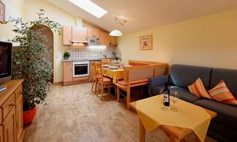 A cozy holiday apartment with a well-equipped kitchen and a dining area. The living area is bright and friendly designed.