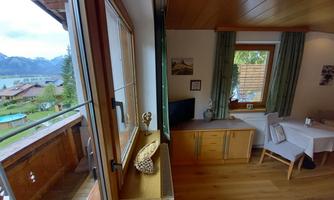 A cozy holiday apartment with a view of the mountains and the lake. Bright furniture and inviting windows create a pleasant atmosphere.
