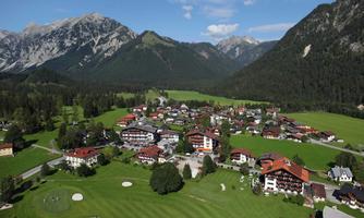 A picturesque village surrounded by mountains and meadows. The red roofs of the houses form a beautiful contrast to the green landscape.