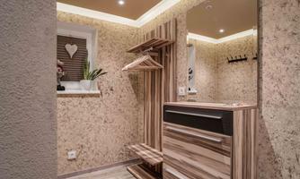A modern hallway with wooden shelves and a mirror. The walls are in neutral tones and there is a small plant on the windowsill.