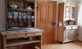 A cozy room with wooden shelves and furniture. There is a table, a door, and a carpet on the floor.