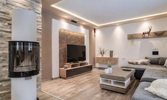 A modern living room with a beautiful fireplace, a TV on the wall, and stylish furniture. The room is bright and inviting, with warm lighting accents.