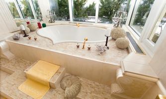 An elegant bathroom with a large, curved bathtub and plenty of natural light. The surroundings are stylishly decorated with decorations and plants.