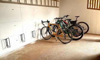 A garage with several bicycles and wall mounts. The space is bright and tidy.