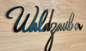 A decorative sign with the inscription "Forest Magic". The background is made of light wood.