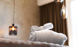 An elegant towel lies on a table, surrounded by soft lights and warm colors. The room conveys a relaxing and luxurious atmosphere.