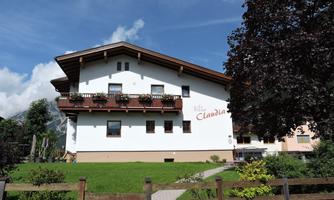 A charming building with a traditional alpine design. Surrounded by green landscape and trees.