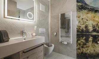 A modern bathroom with a stylish shower and a wooden sink. The room is bright and neutrally designed with elegant accents.