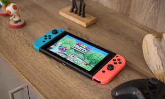 A Nintendo Switch is lying on a wooden table. The game "Mario Party" is displayed on the screen.