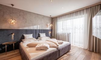 A modern bedroom with a large bed and cozy pillows. The light-flooded room design creates an inviting atmosphere.