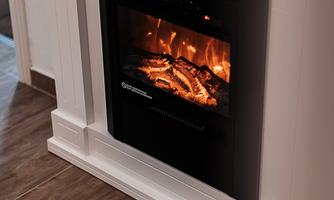 A modern fireplace in a stylish room. The flames glow warmly and create a cozy atmosphere.