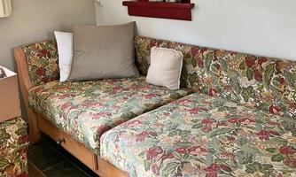 A cozy sofa with a floral pattern and various cushions. The room feels bright and inviting.