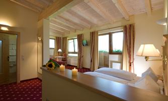 A cozy room with a modern wooden design. Large windows let in plenty of sunlight.