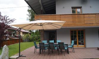 A beautiful garden with a terrace and a large sun umbrella. Several chairs are around the table, perfect for sociable evenings outdoors.