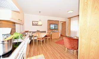 A cozy dining kitchen with wooden furniture and a dining table. The room has a warm, inviting character and plenty of natural light.