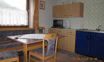 A cozy kitchen area with a dining table and chairs. The kitchen is modern and functionally designed.