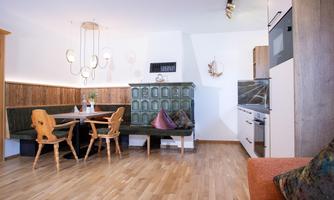 A modernly designed kitchen with a dining area and an elegant wooden floor. The decor combines traditional elements with contemporary design.