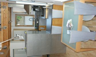 A modern kitchen with a table and chairs. The kitchen is bright and has a clean, functional design.