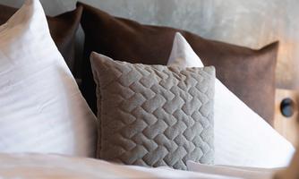 Cushions on a bed with a stylish, modern environment. The different textures create a cozy atmosphere.
