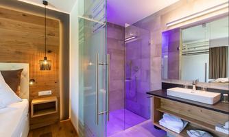 A modern bathroom with a walk-in shower and stylish wood and glass elements. Soft lighting creates a relaxed atmosphere.