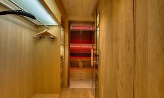 An elegant wooden dressing room with space for clothes and a mirror. The warmly lit ambiance creates a cozy atmosphere.