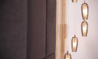 A modern room with hanging glass candle holders. The warm lights create a cozy atmosphere.